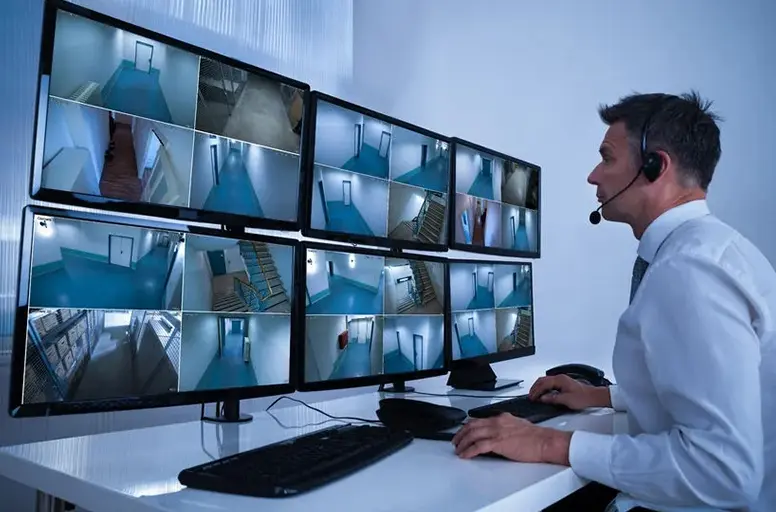 A man sitting at his computer with multiple monitors.