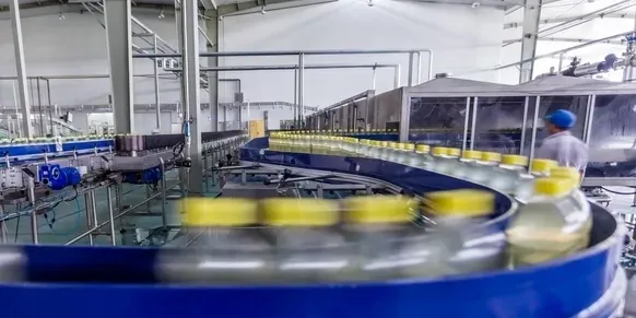 A conveyor belt with many cans of beer on it.