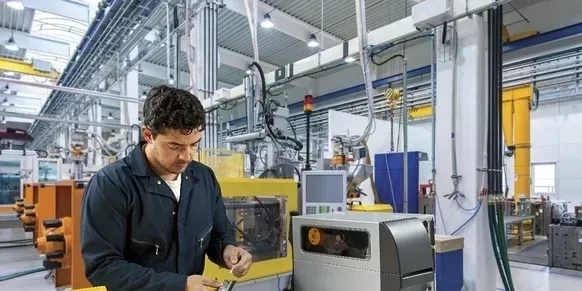 A man working in an industrial setting with machinery.